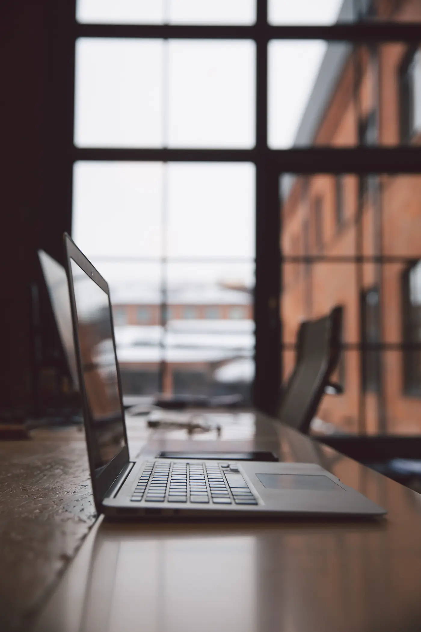 A desk beside a tall window.