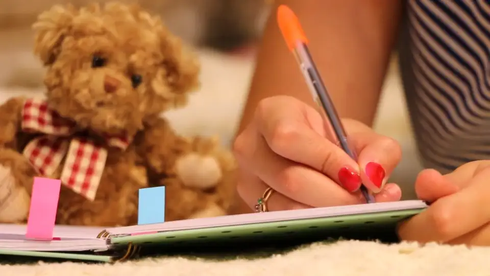 A child colouring at a table.